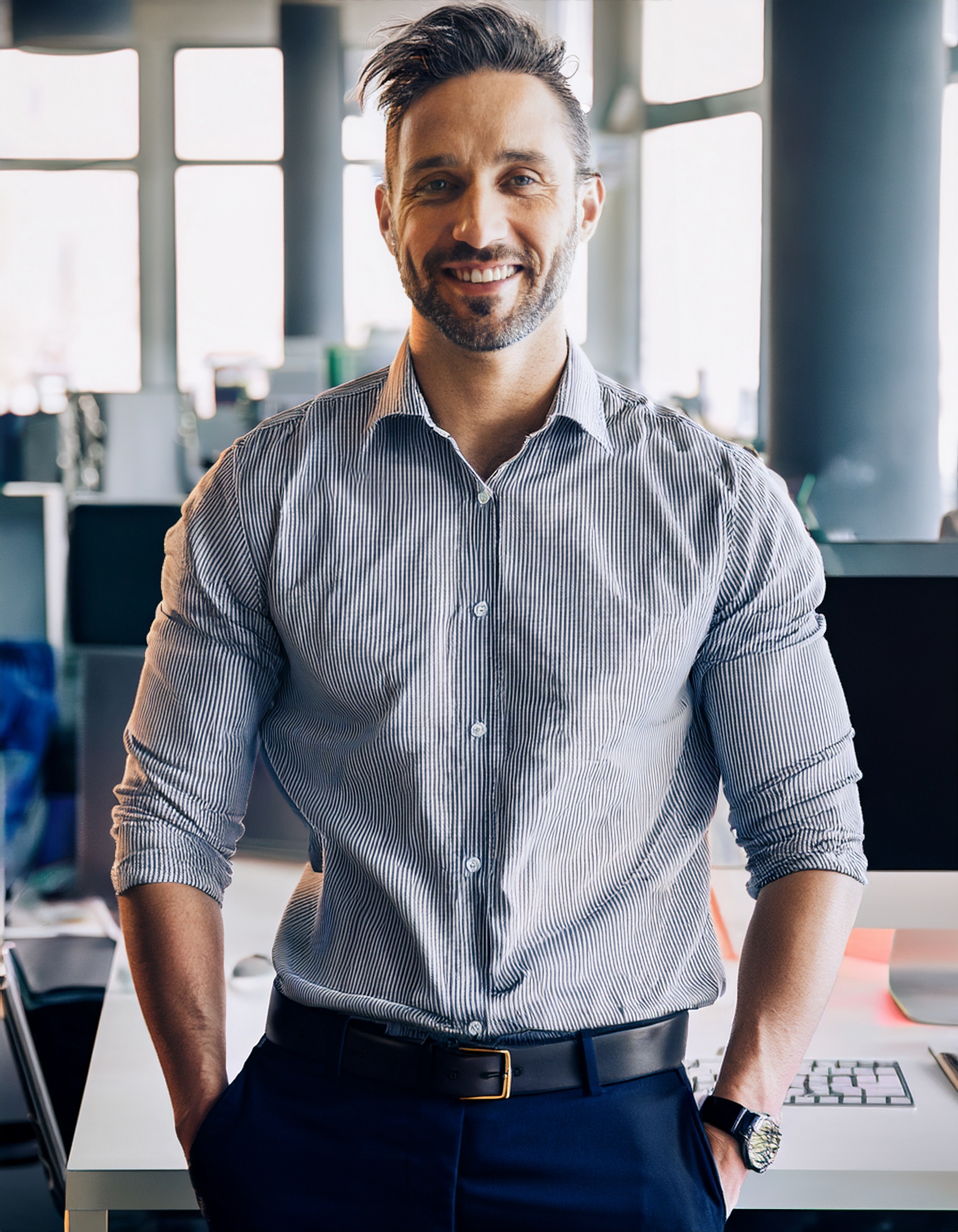 Person in moderner Geschäftskleidung, lächelnd, Bürohintergrund